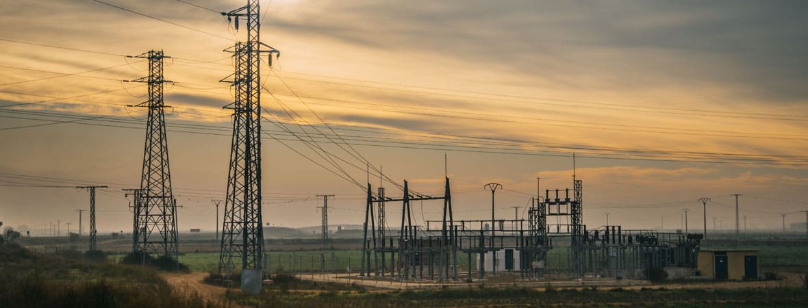 An electricity substation in the countryside at sunrise.